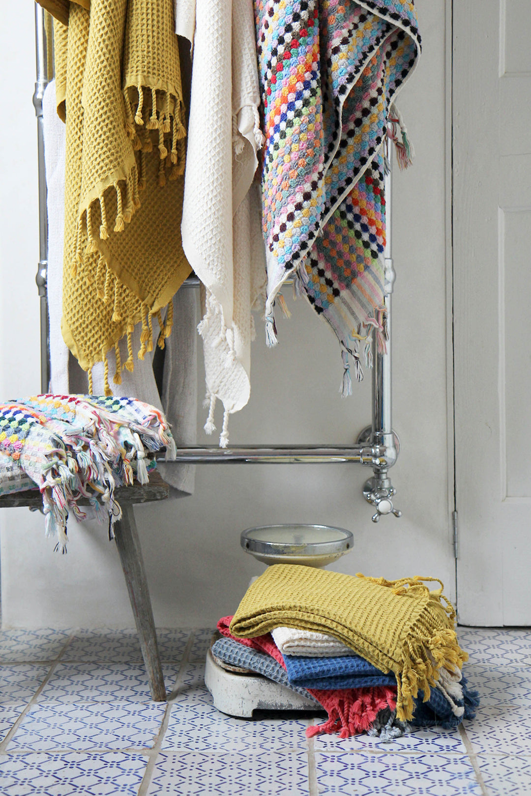 Vintage bathroom scales with colourful turkish towels and waffle cotton towels