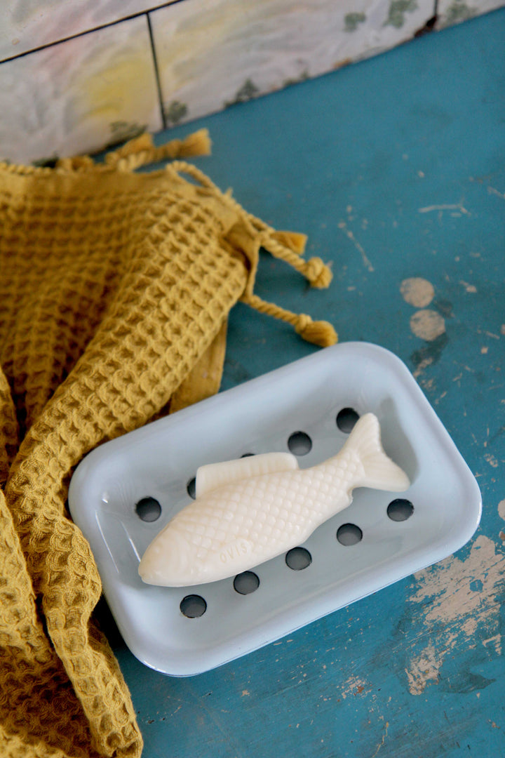 fish shaped soap on blue enamel soap dish with mustard waffle towel