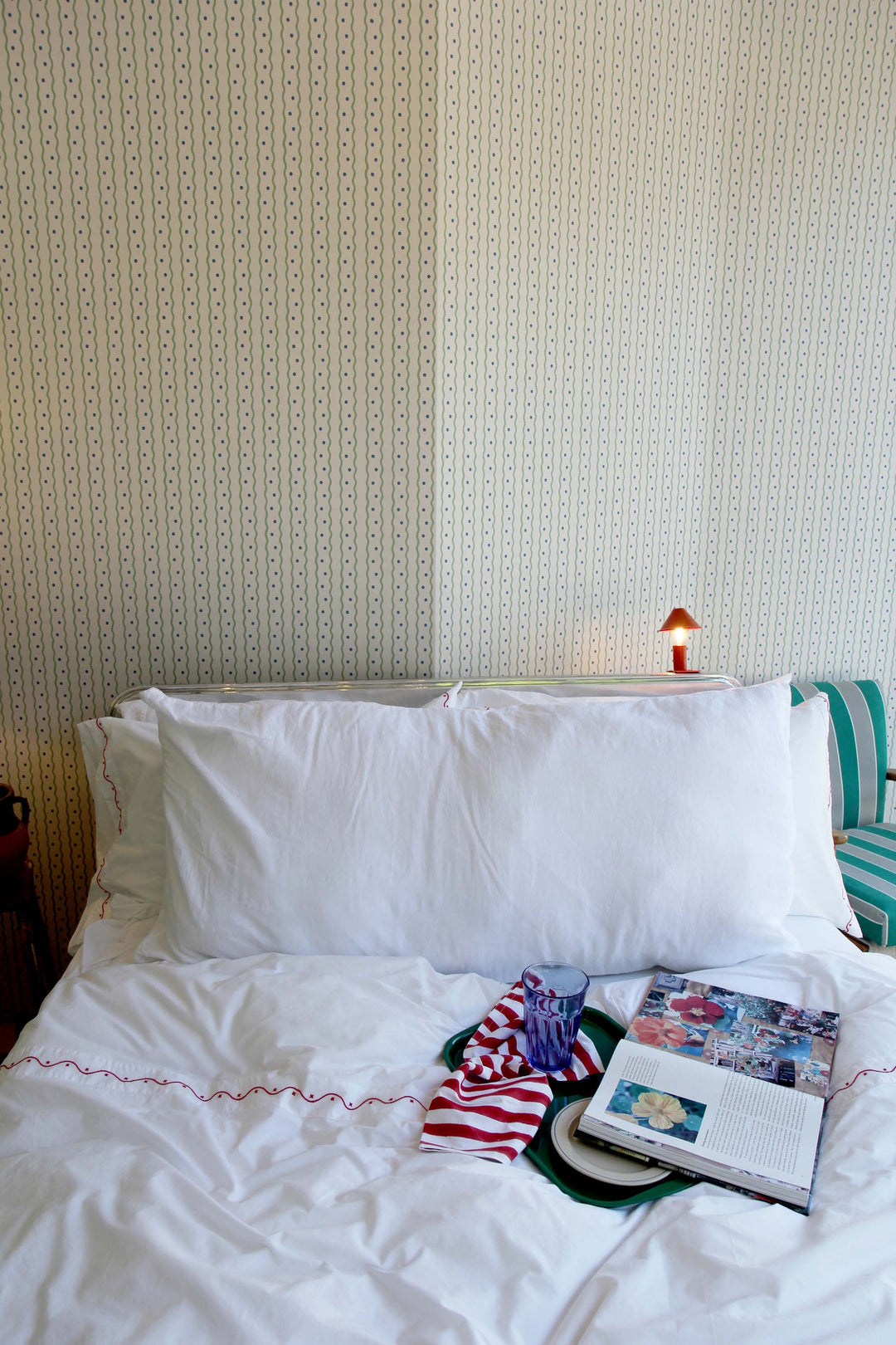 limy bolster cushion in white linen on bed