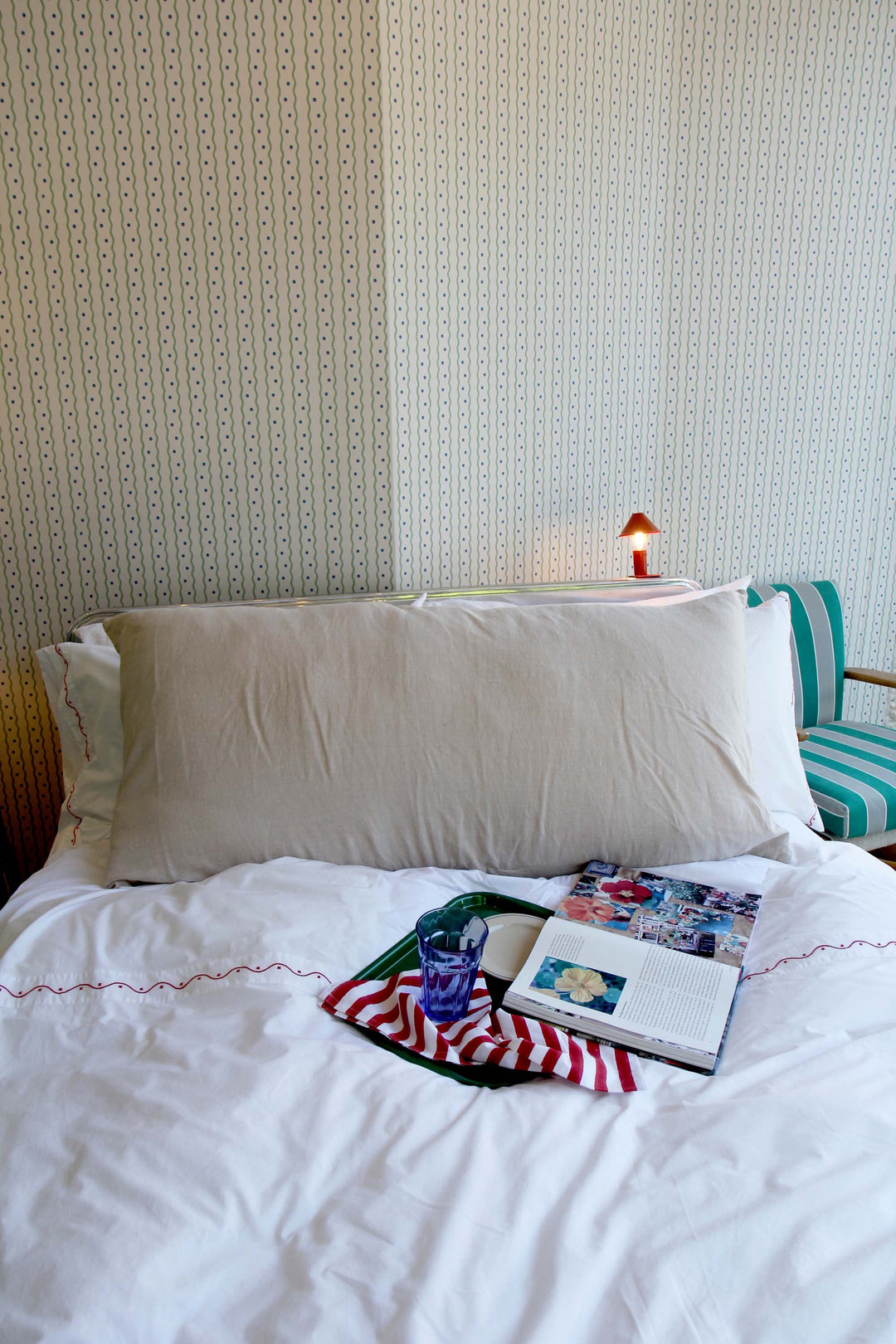 limy bolster cushion in natural linen on bed