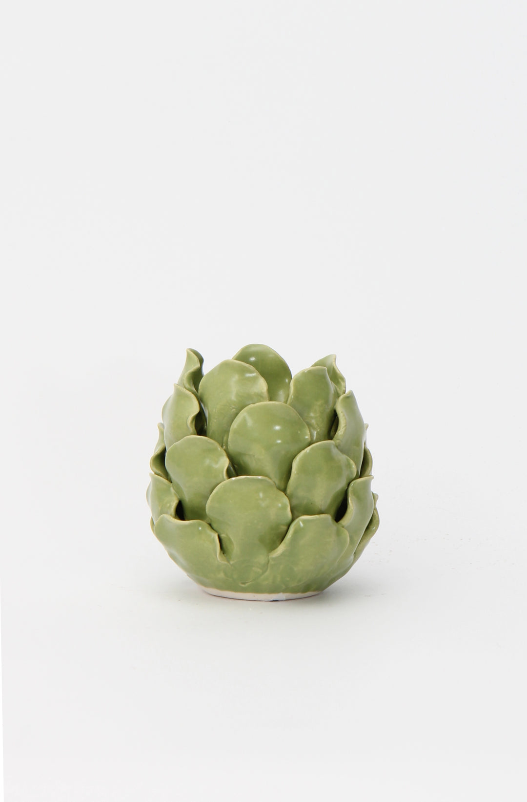 A porcelain artichoke-shaped candle holder with a vibrant green glaze.