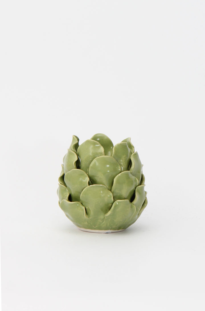 A porcelain artichoke-shaped candle holder with a vibrant green glaze.