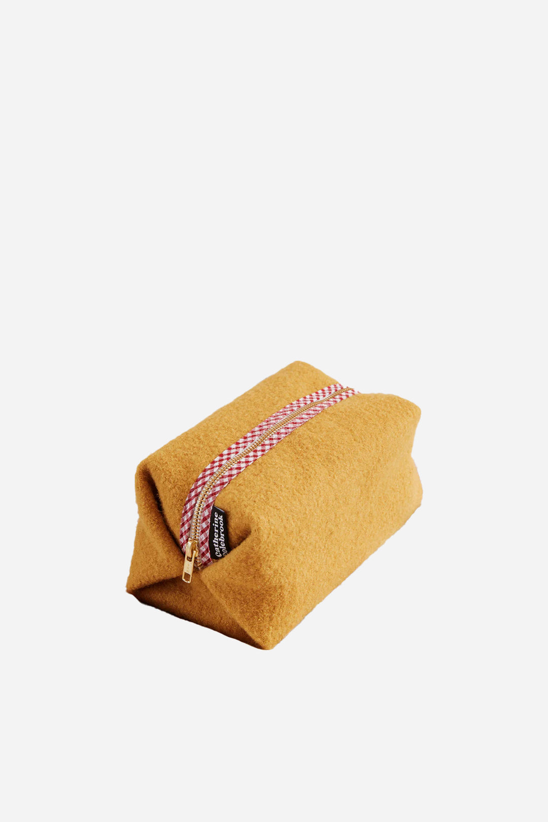 Mustard-colored pouch with a pink and white striped string on a light beige background