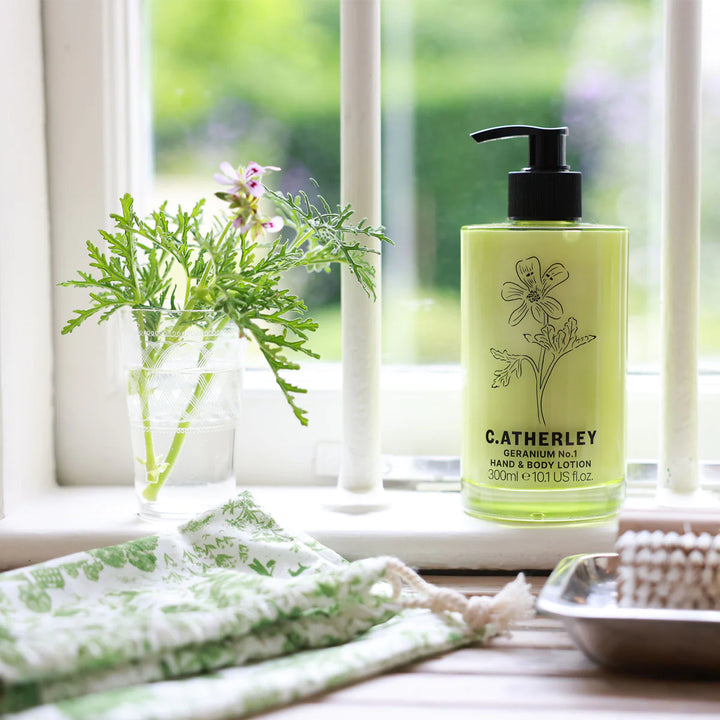 c.atherley geranium body lotion in green glass bottle on window sill