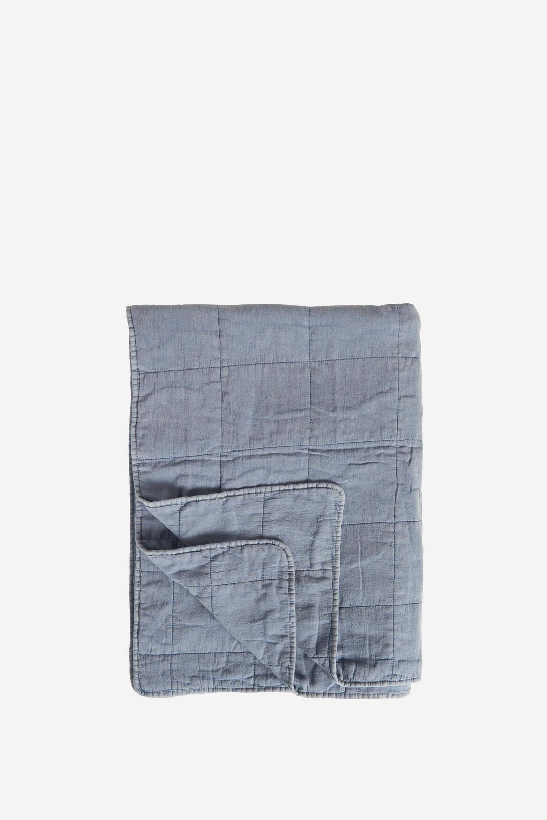 Folded blue quilt on a white background