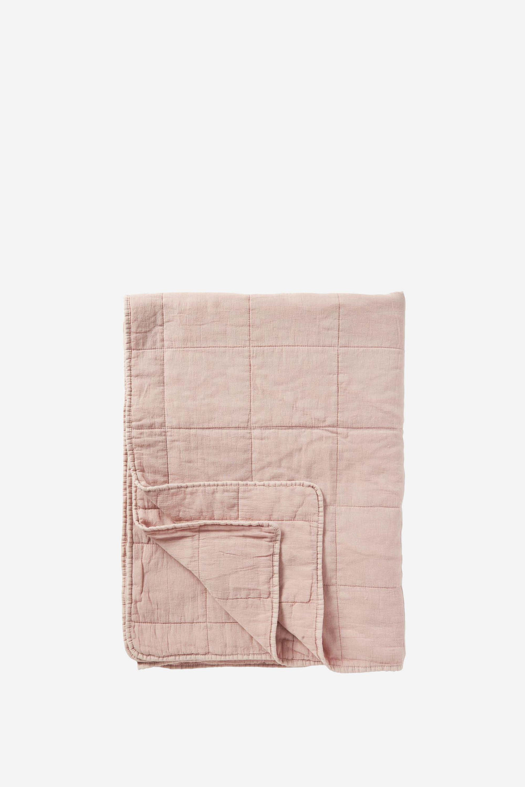 Folded pink quilt on a white background