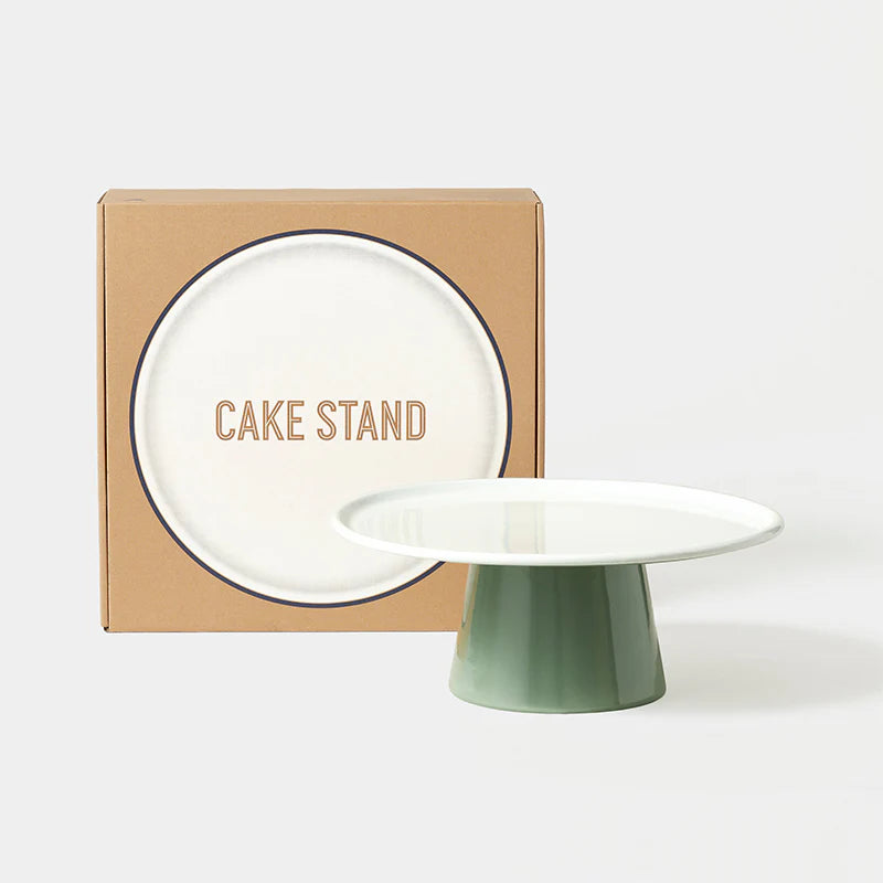 falcon enamelware Green cake stand in front of a cardboard box with 'CAKE STAND' text on a white background
