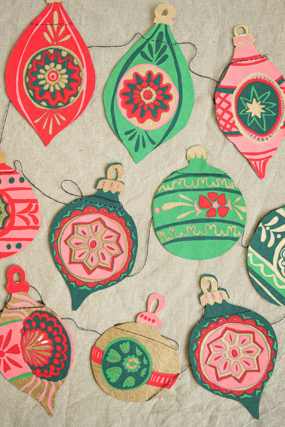 Colorful decorative bauble garland on a textured beige background