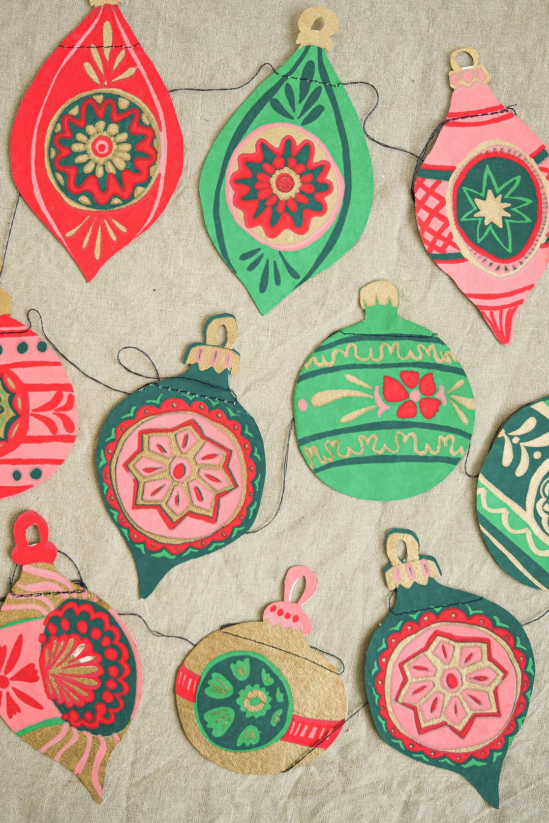 Colorful decorative bauble garland on a textured beige background