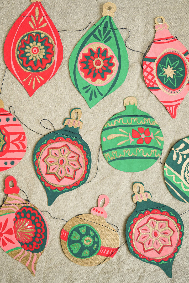 Colorful decorative bauble garland on a textured beige background