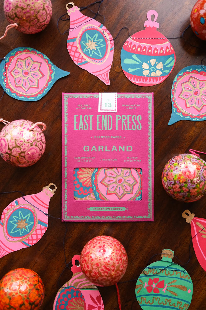 Decorative garland packaging with colorful ornaments on a wooden surface