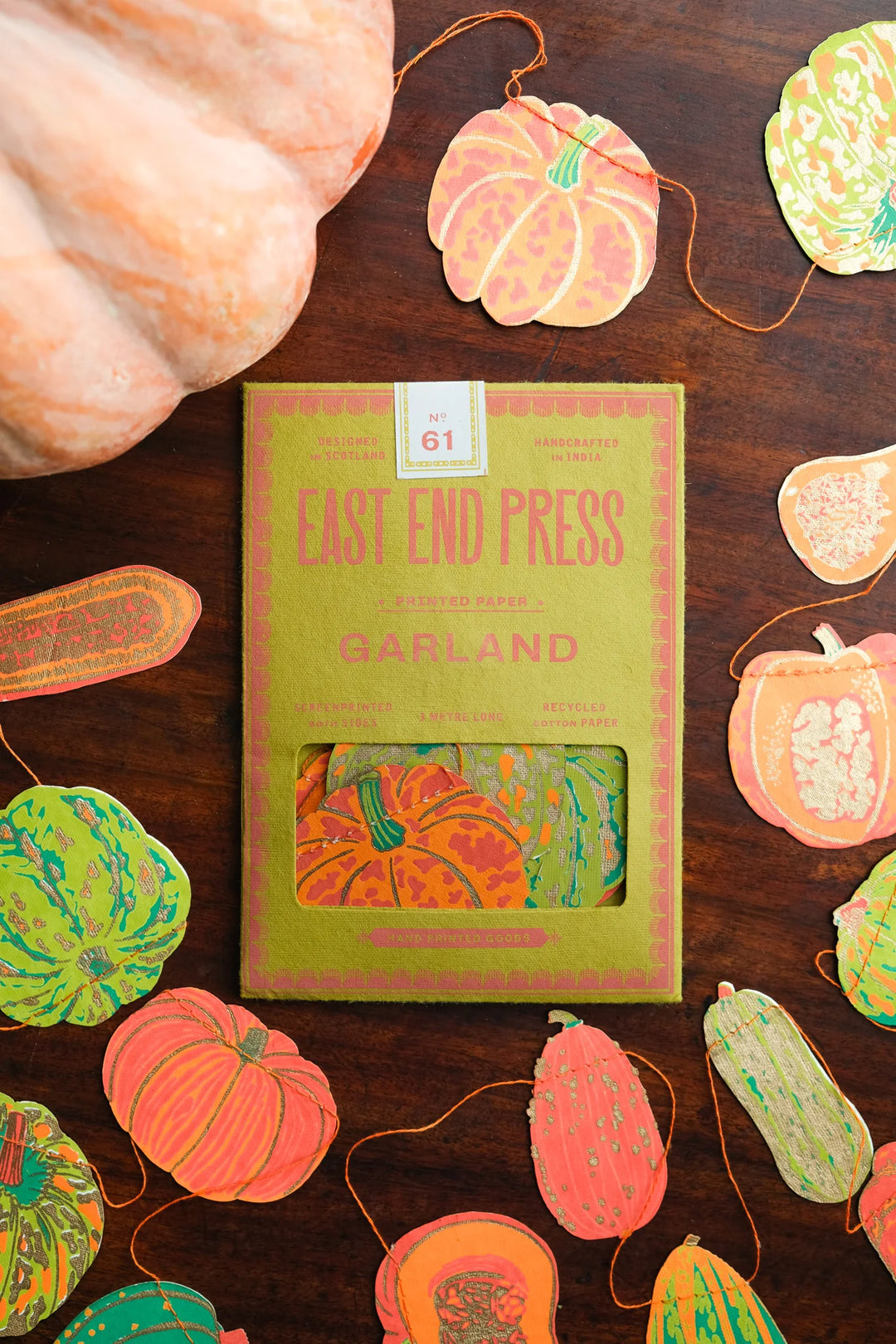 East End Press Garland packaging with pumpkins on a wooden surface
