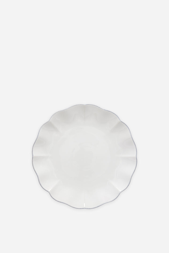 White ceramic plate with scalloped edge on a white background