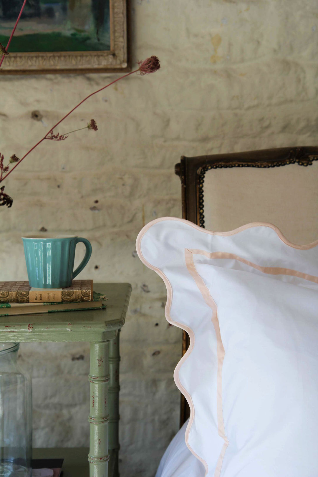 Rose wiggle pillowcase on bed with vintage bedside table