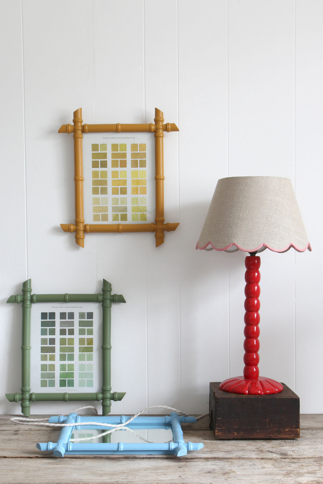 red wooden bobbin lamp and faux bamboo framed prints