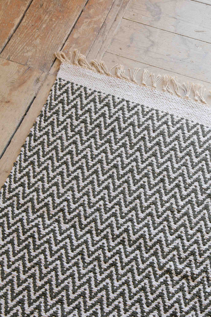 khaki and cream jute and cotton woven zigzag rug on wooden floor boards