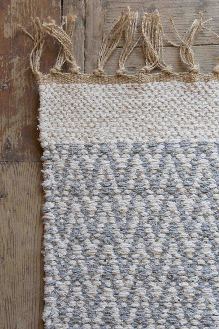 grey and cream jute and cotton woven zigzag rug on wooden floor boards