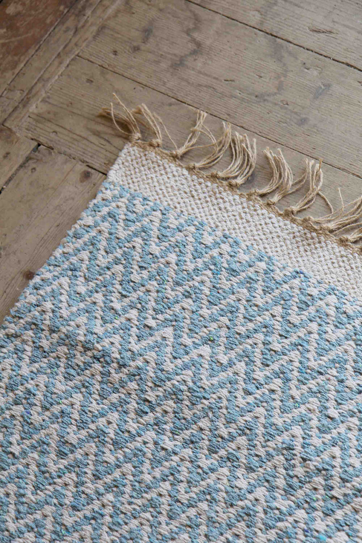 blue and cream jute and cotton woven zigzag rug on wooden floor boards