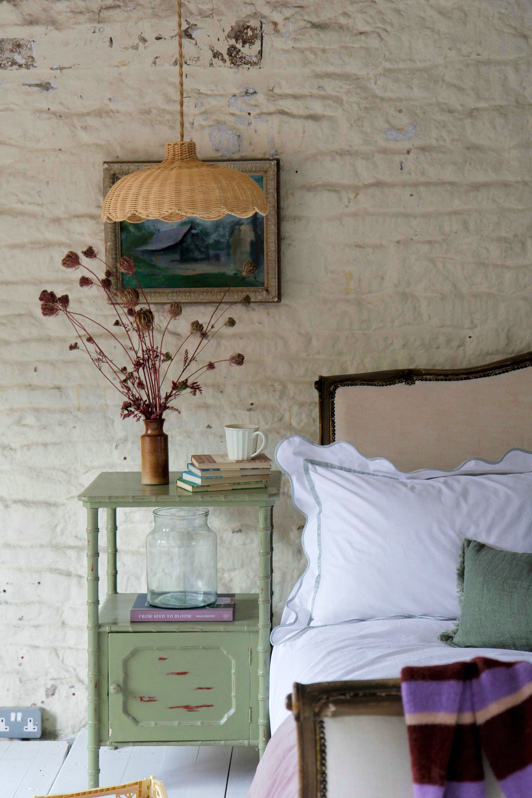 antique french bed and faux bamboo bedside table in rustic country bedroom