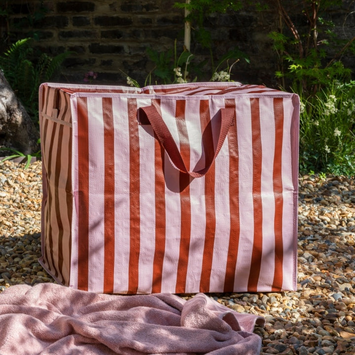 Striped fabric bag with handles on a stone surface outdoors
