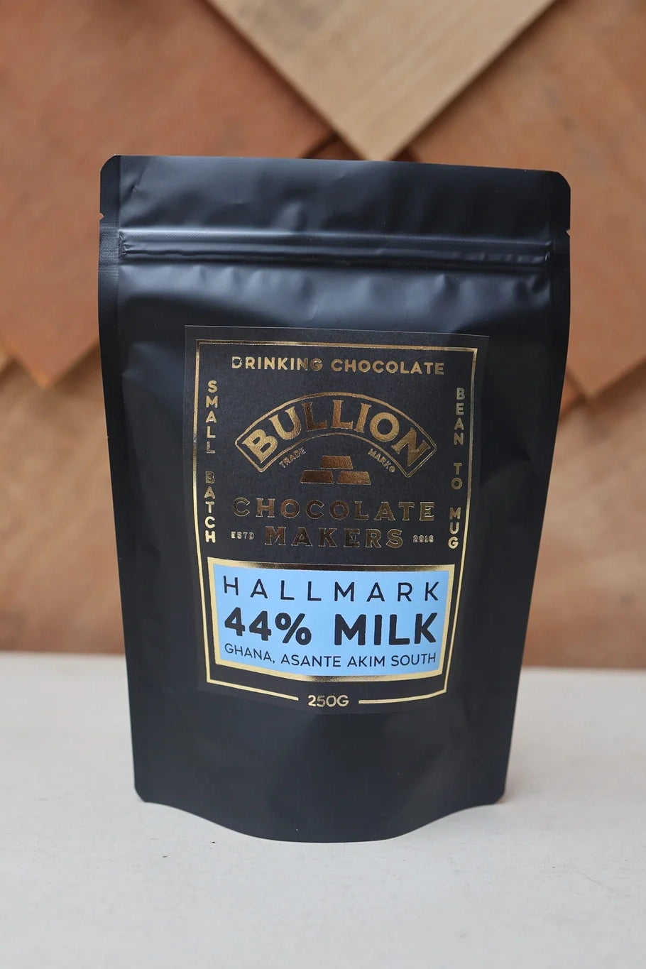 Bullion Drinking Chocolate package with a gold label on a wooden background