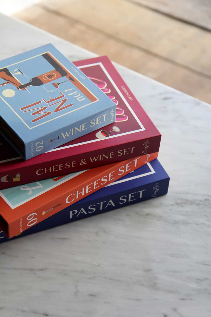 Stack of books titled 'Wine Set', 'Cheese & Wine Set', and 'Cheese Set' on a marble surface.