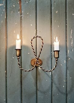 Decorative wall sconce with candles on a wooden background