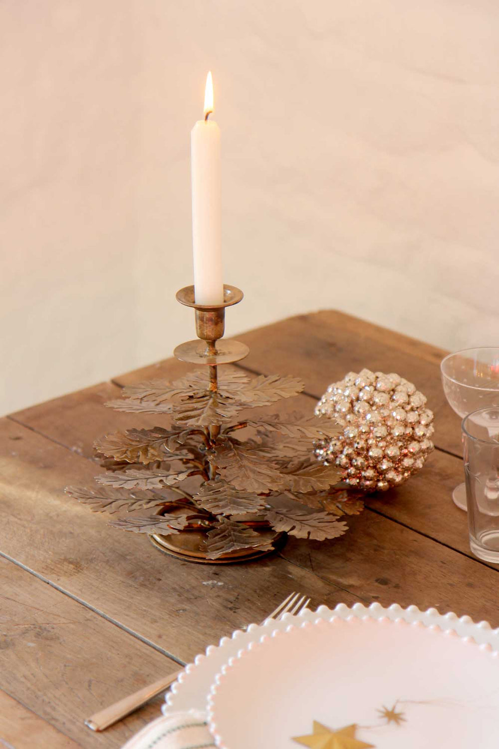 Candle in a decorative holder on a wooden table with a soft background