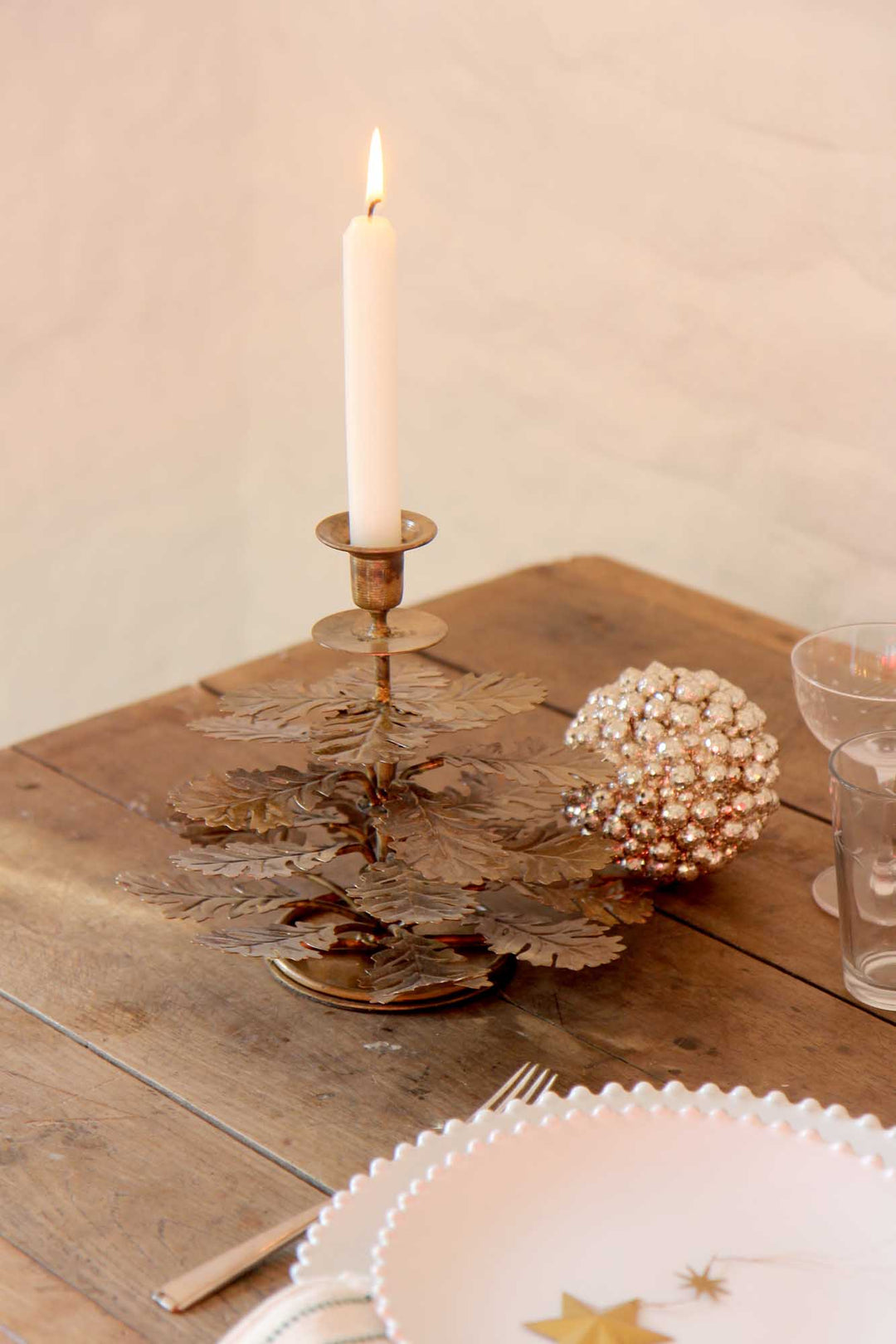 Candle in a decorative holder on a wooden table with a soft background
