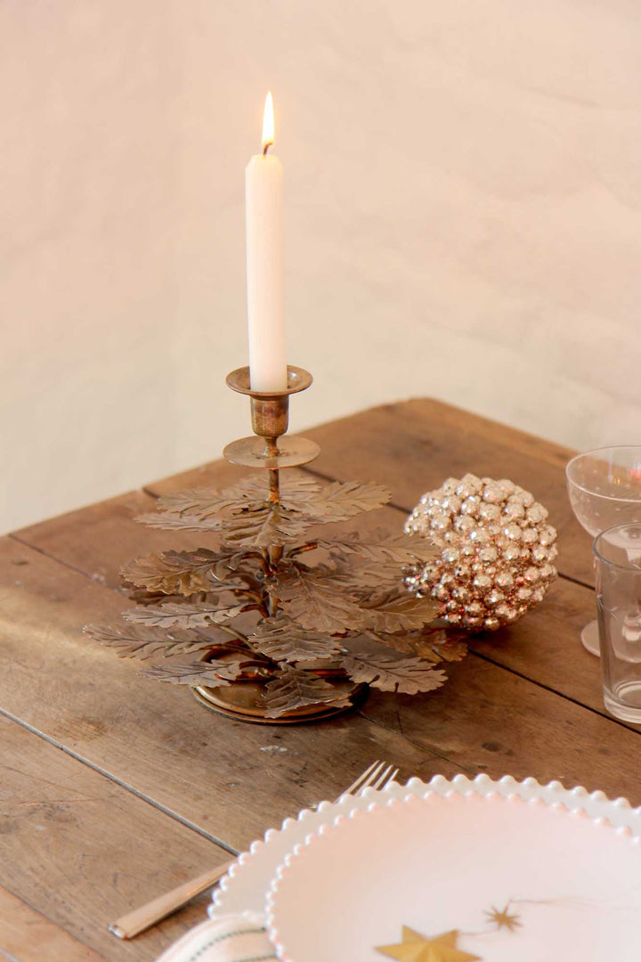 Candle in a decorative holder on a wooden table with a soft background