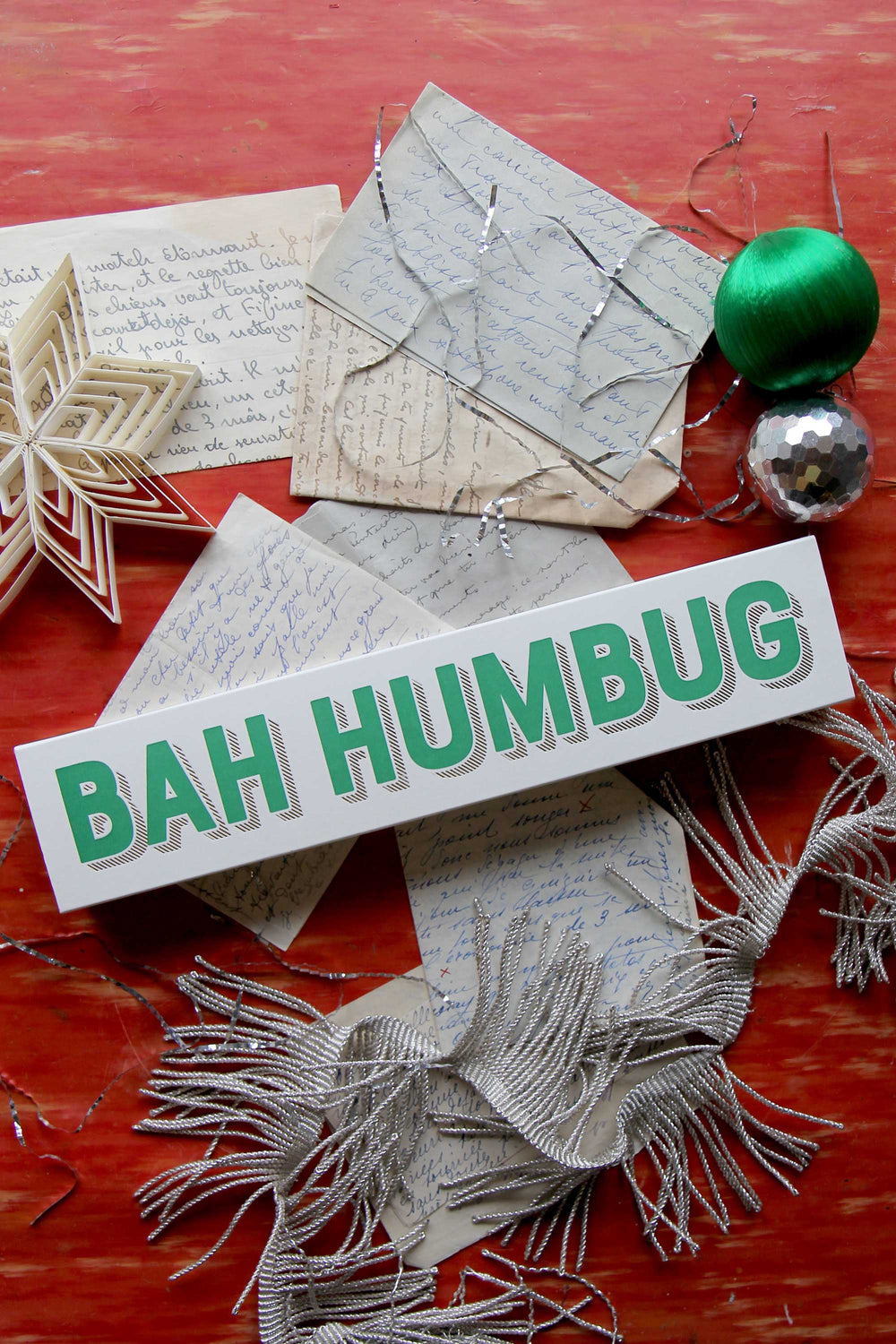 Decorative matches with 'BAH HUMBUG' on a red surface with festive items.