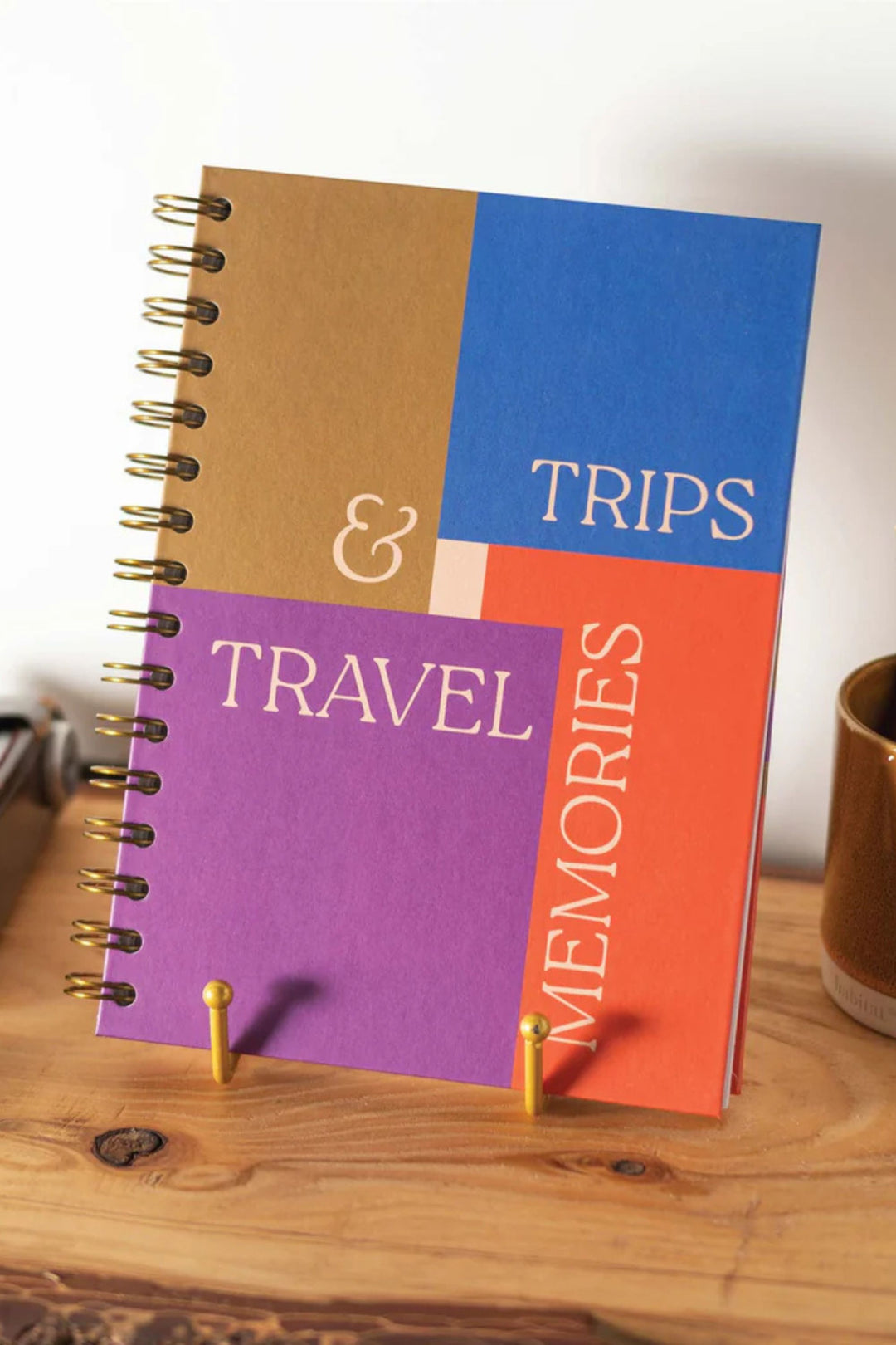 Notebook with 'Trips & Travel Memories' on a wooden surface