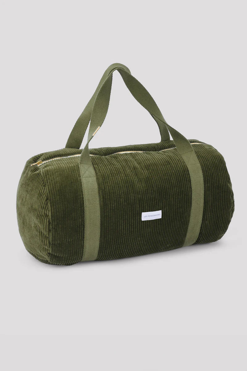 Green duffel bag with a strap on a light gray background