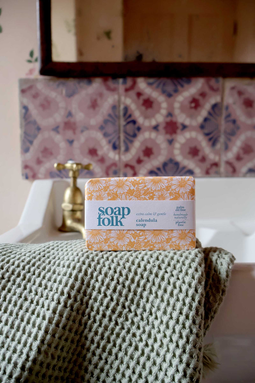 Soap Folk product on a bed with a decorative headboard and wall tiles.