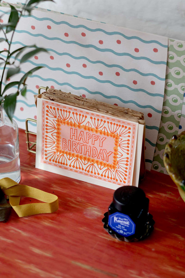 Happy Birthday card with decorative elements on a wooden surface