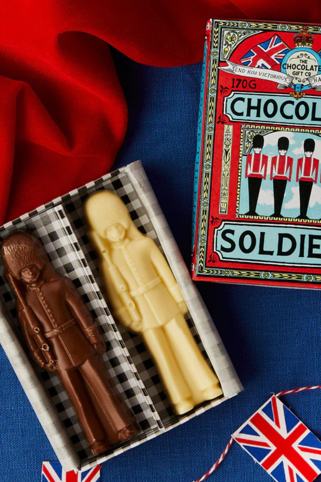 Two chocolate soldiers in a matchbox with a vintage-style packaging box on a blue background.