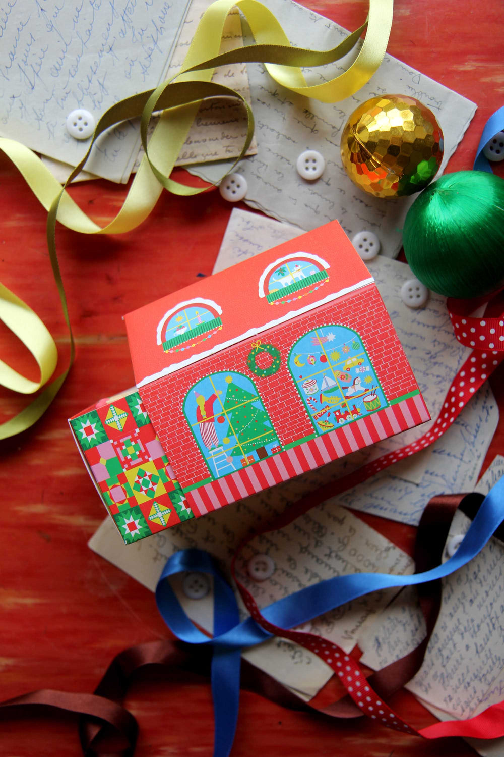 Colorful matches with festive design on a wooden surface with ribbons and ornaments.