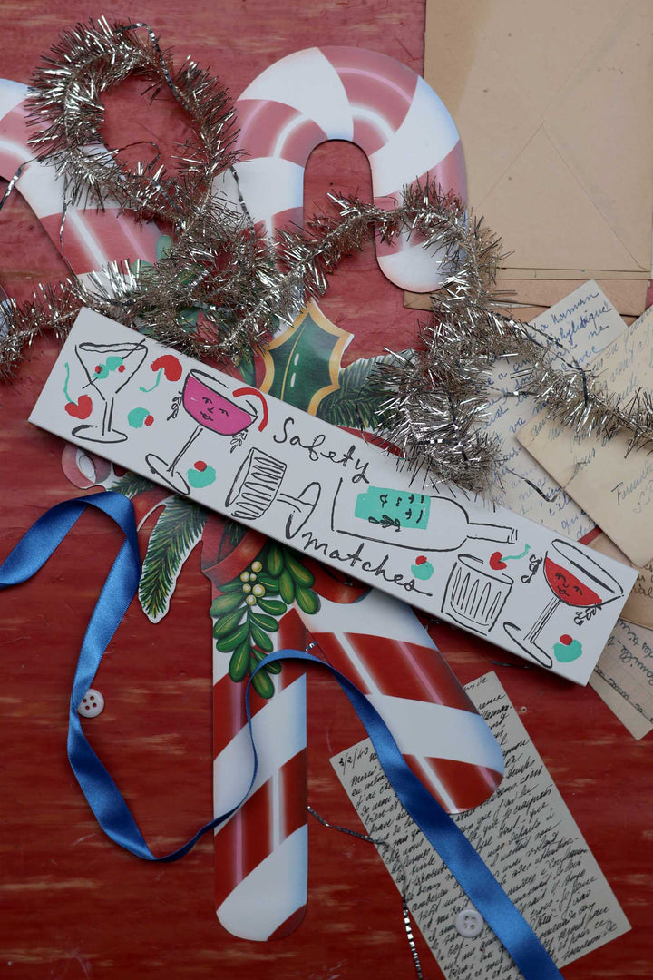 A hand-painted wooden Christmas sign reading &