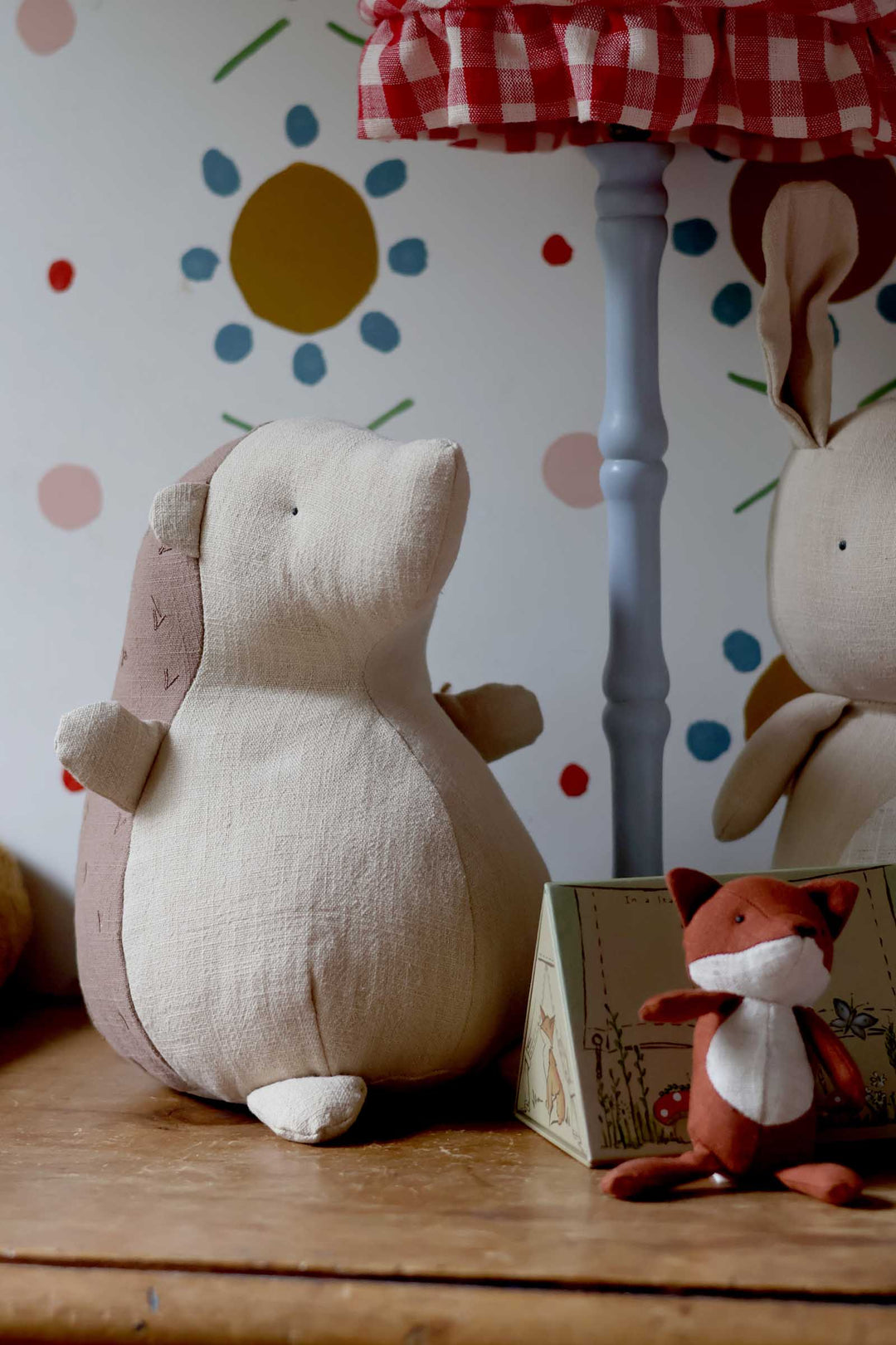 Plush toys on a wooden surface with a colorful polka dot wall in the background