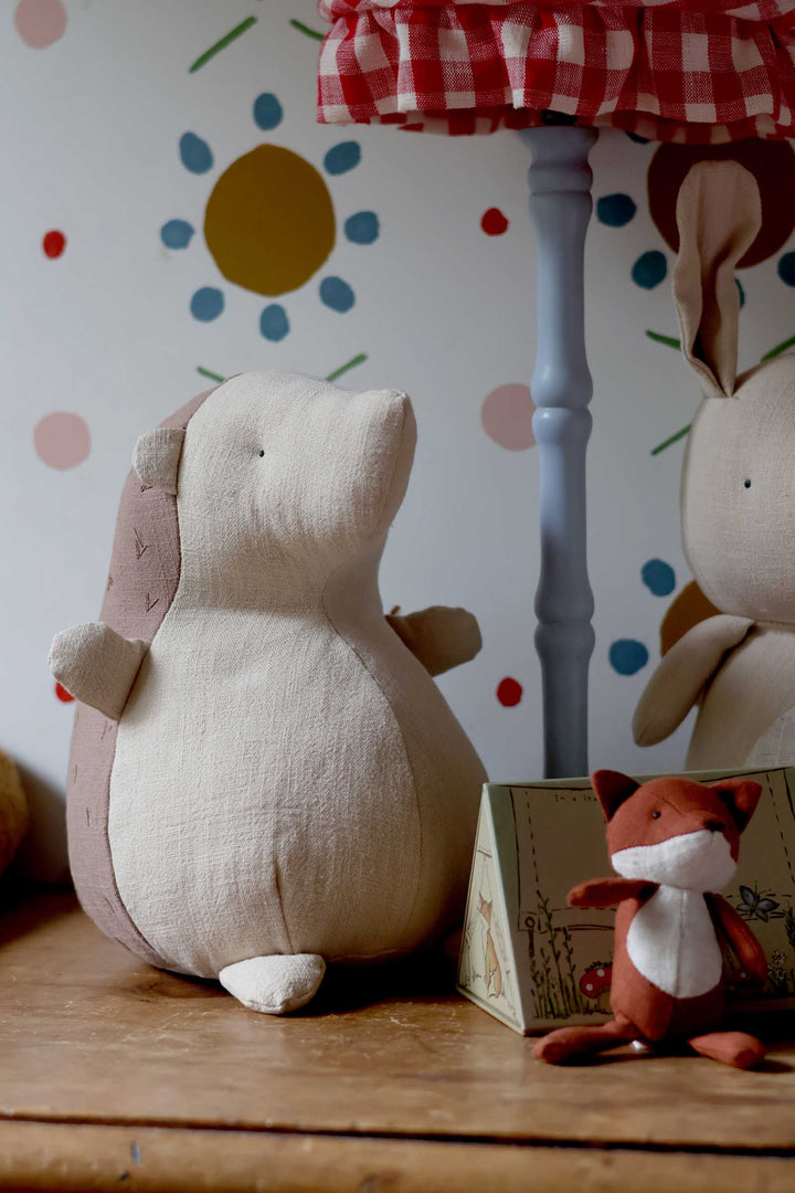 Plush toys on a wooden surface with a colorful polka dot wall in the background