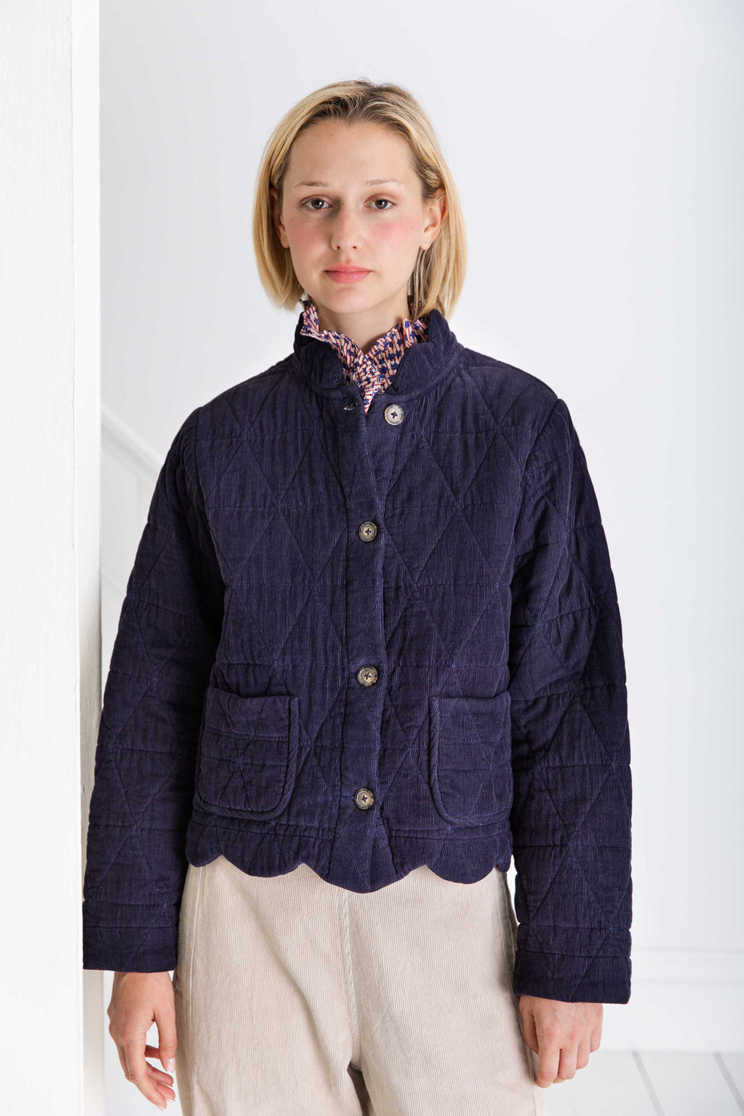 Woman wearing a dark blue jacket with a white background