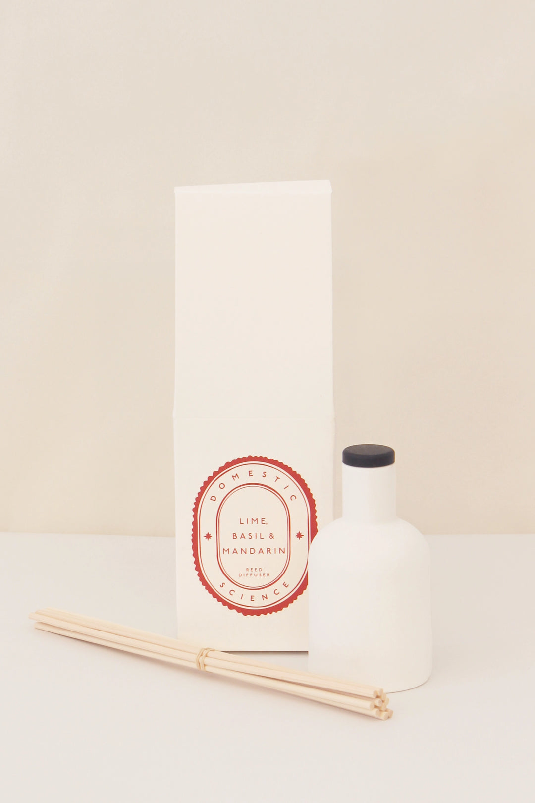 lime basil and mandarin diffuser and ceramic vessel and reeds on white background