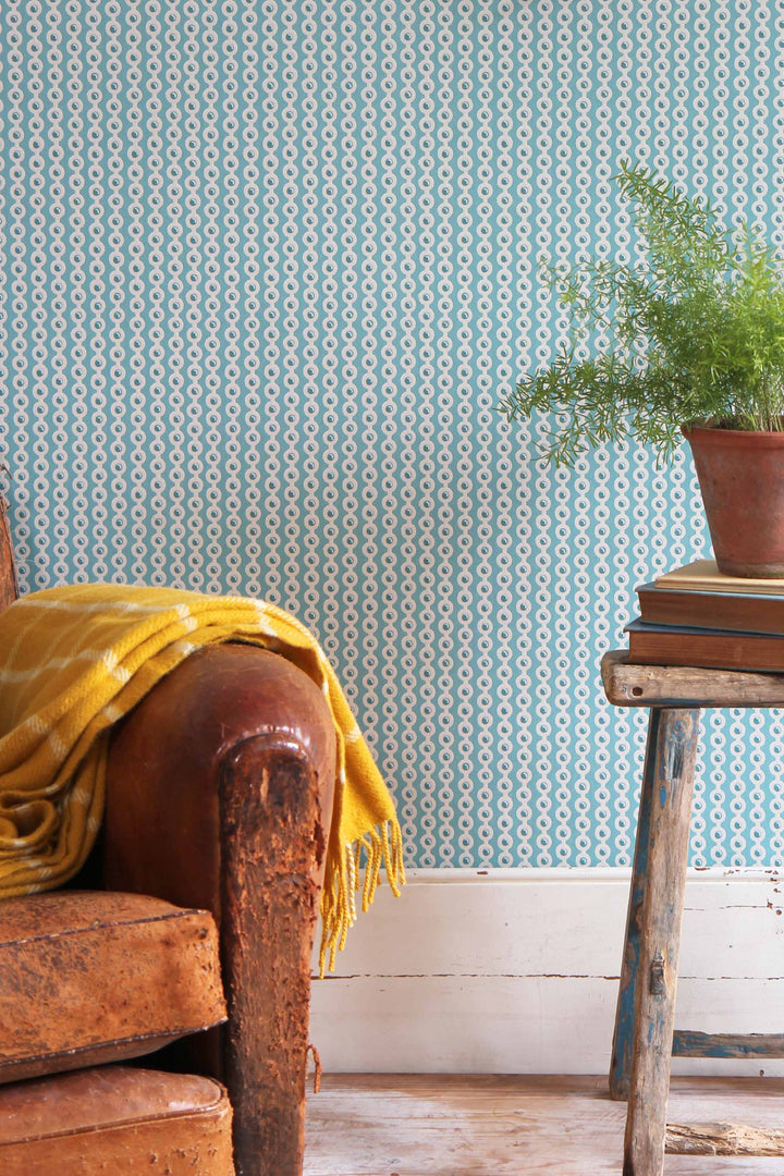 deauville blue spot wallpaper in celadon with vintage leather armchair, side table and pot plant