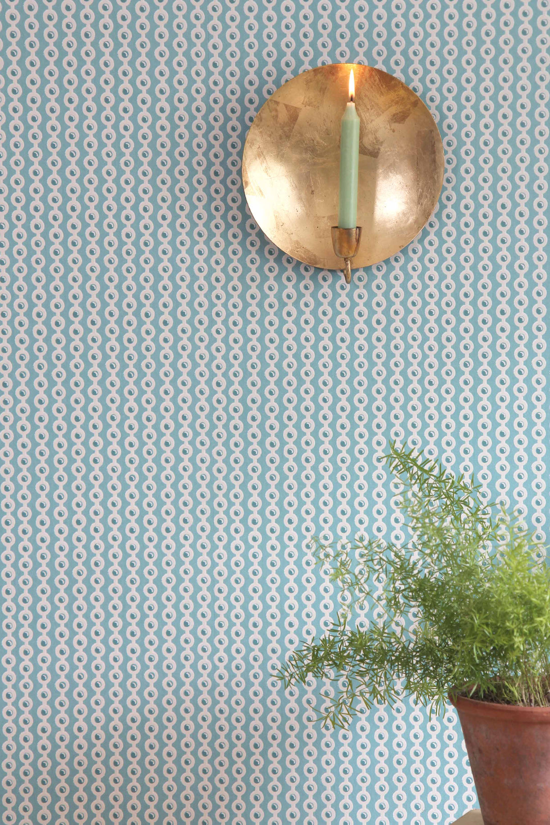 deauville blue spot wallpaper in celadon with golden wall sconse and terracotta pot plant