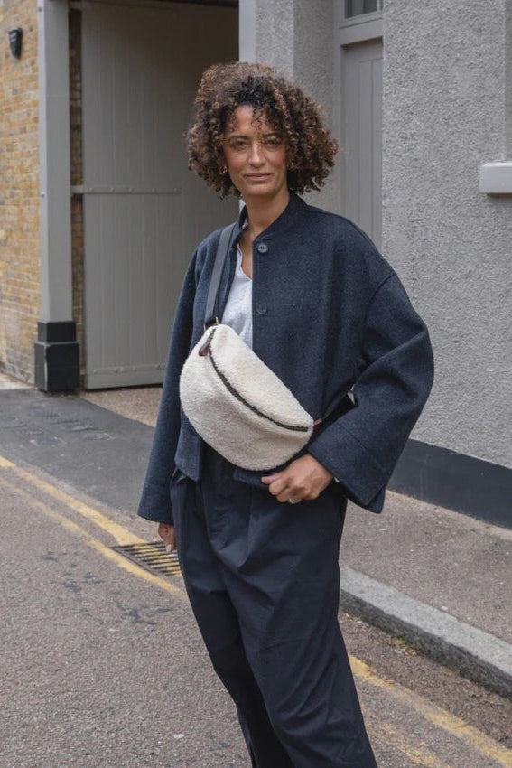 Woman holding a white bag on a street