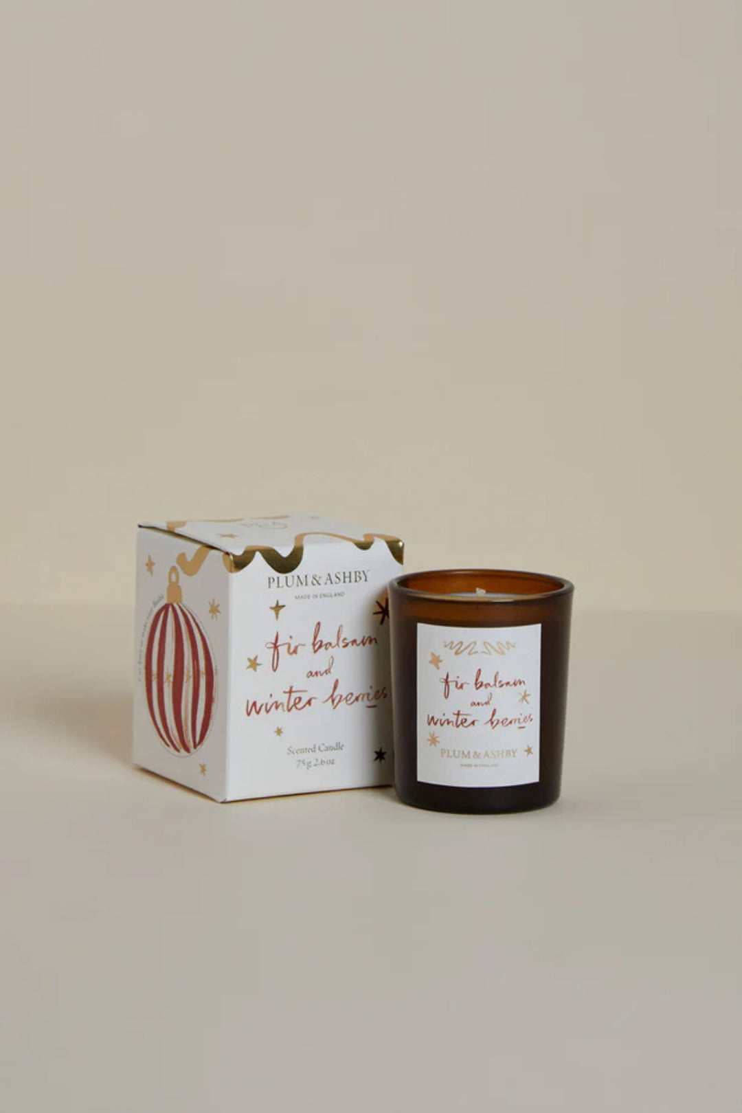 Candle and packaging with decorative elements on a beige background