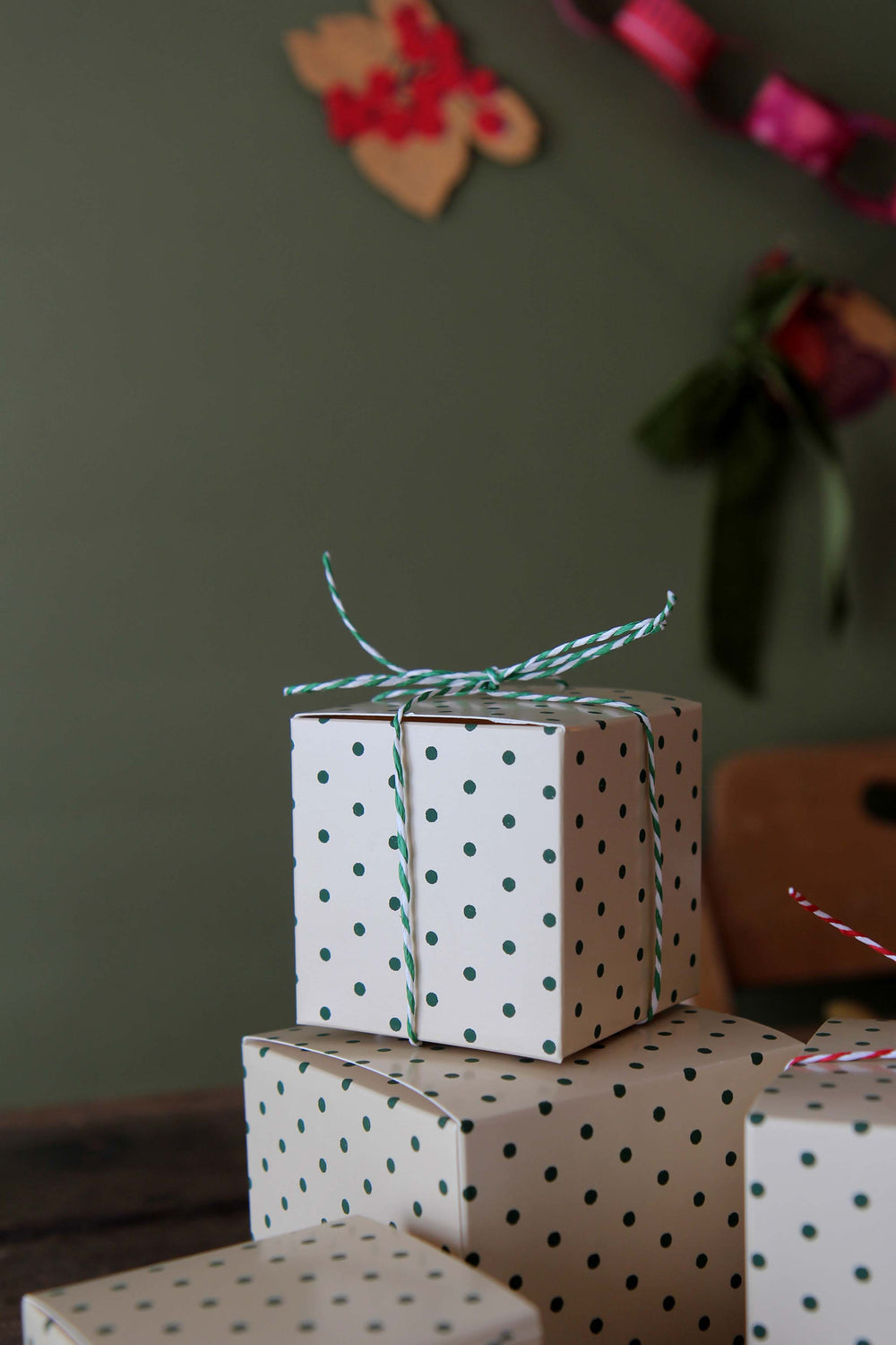 Stack of gift boxes with polka dot pattern and green string on a blurred background