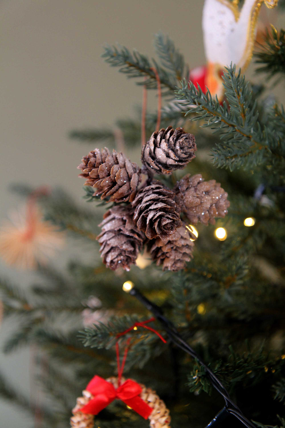 Decorative pine cones on a Christmas tree with blurred background