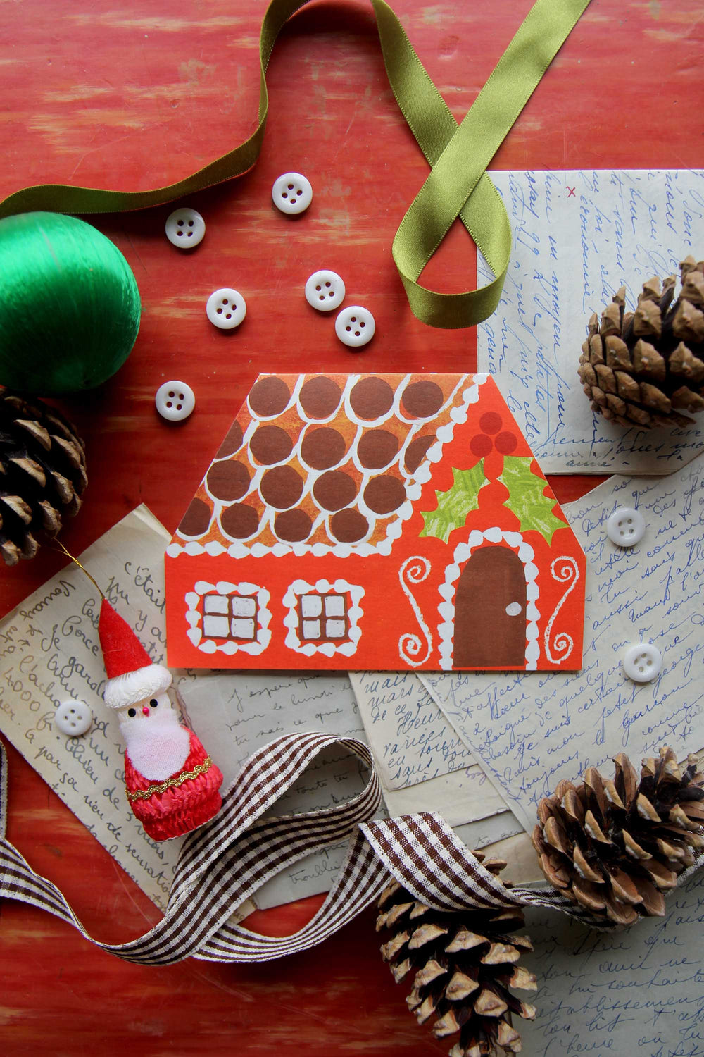 Gingerbread house card with decorative elements on a textured surface