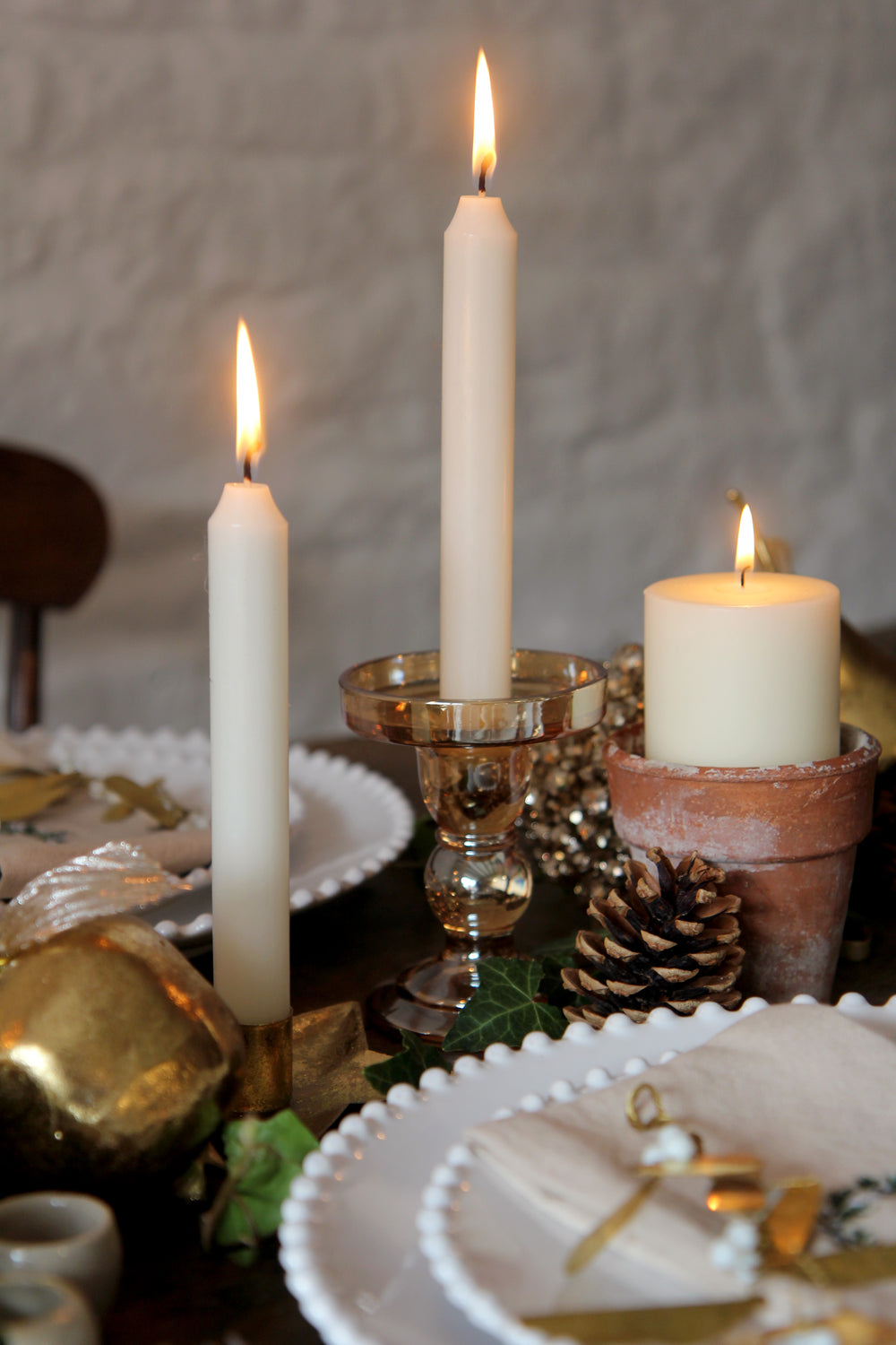 Candles on a table with decorative elements and a textured wall background
